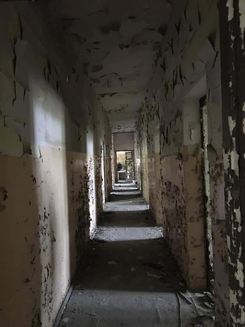 Zdjęcie opuszczonego miejsca: Dwa niewielkie budynki, ruiny i mały komin z drabiną