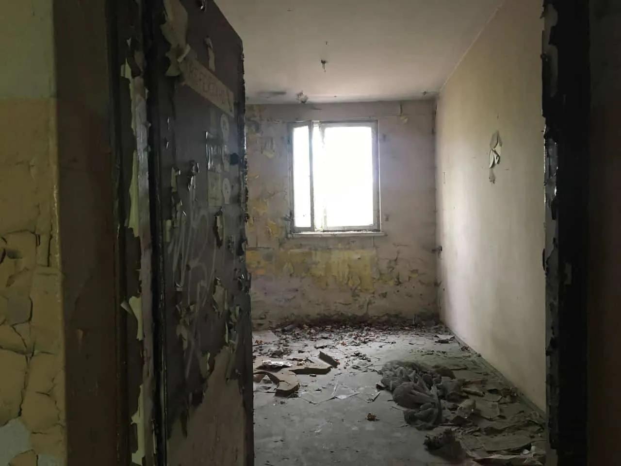 Zdjęcie opuszczonego miejsca: Dwa niewielkie budynki, ruiny i mały komin z drabiną